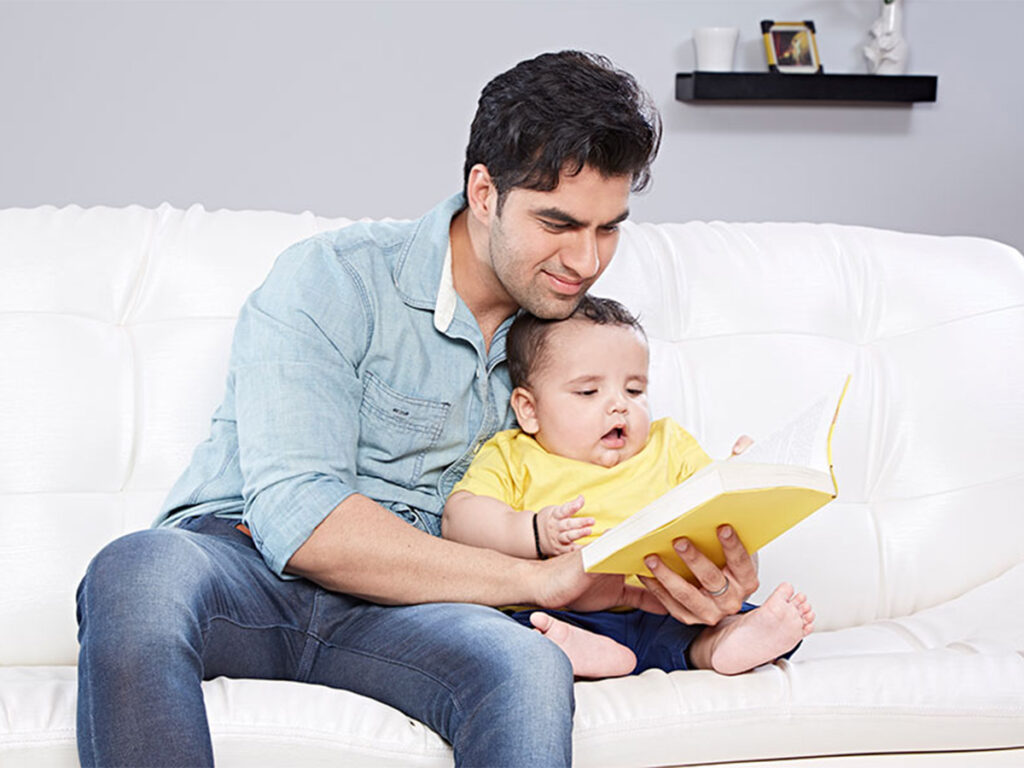 Father Reading a Yellow Book with His Baby